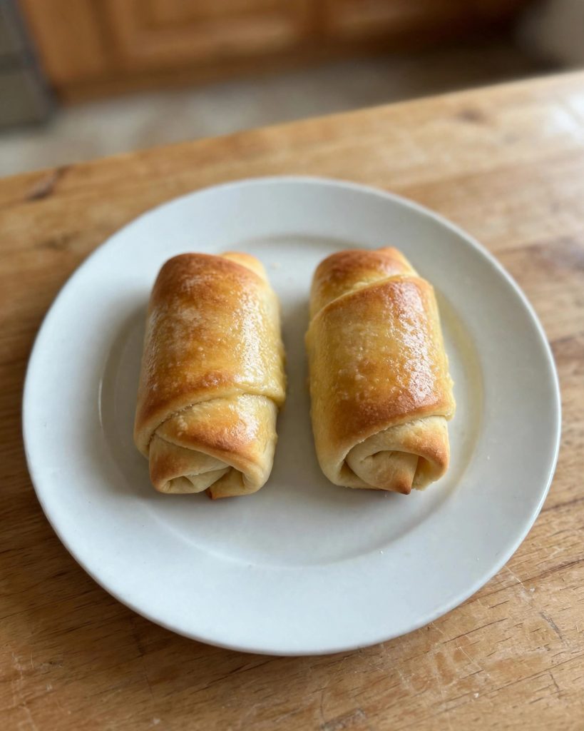 Two Parker House rolls on a small white plate