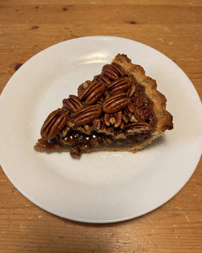 A slice of pecan pie on a white plate