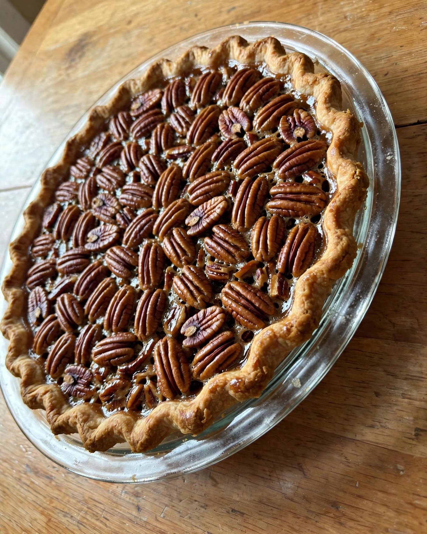 Old-fashioned pecan pie with a glossy pecan top in a pie plate